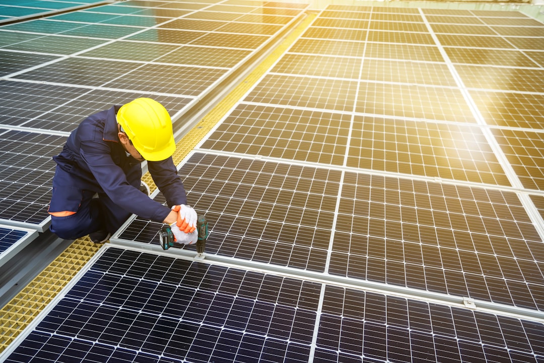 A worker builds a solar panel system on a house roof. An engineer builds a solar panel station on a house roof. Powerful backup power from solar energy
